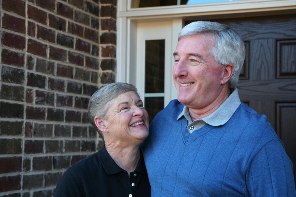 Happy, smiling couple outside their front door